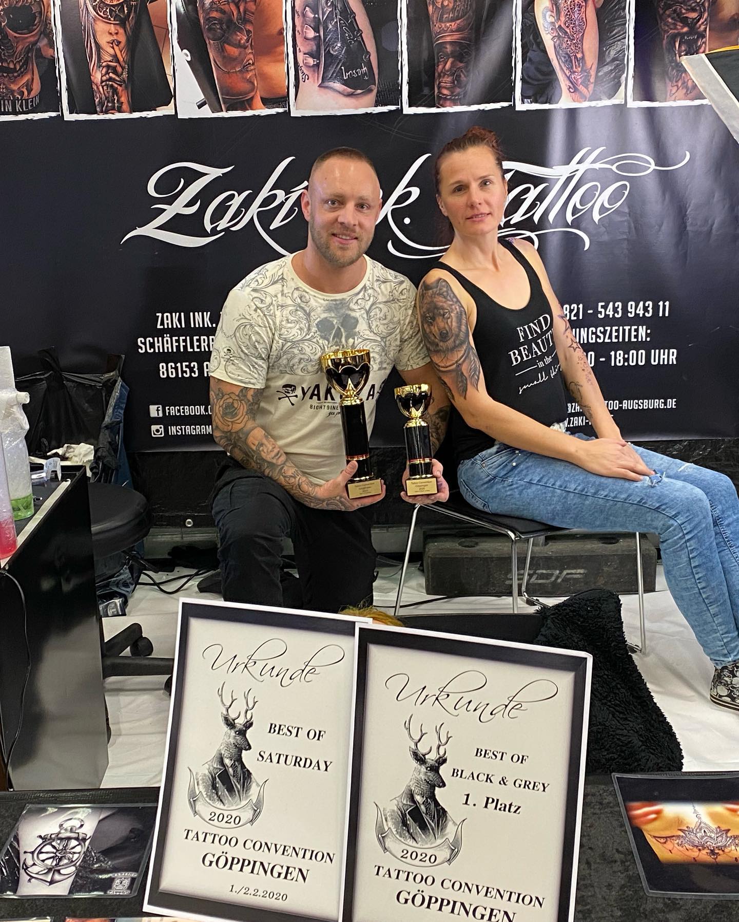 Zaki und Pedro mit ihren Pokalen und Urkunden der Tattoo Convention Göppingen 2020 vor dem Zaki Ink. Tattoo Messestand